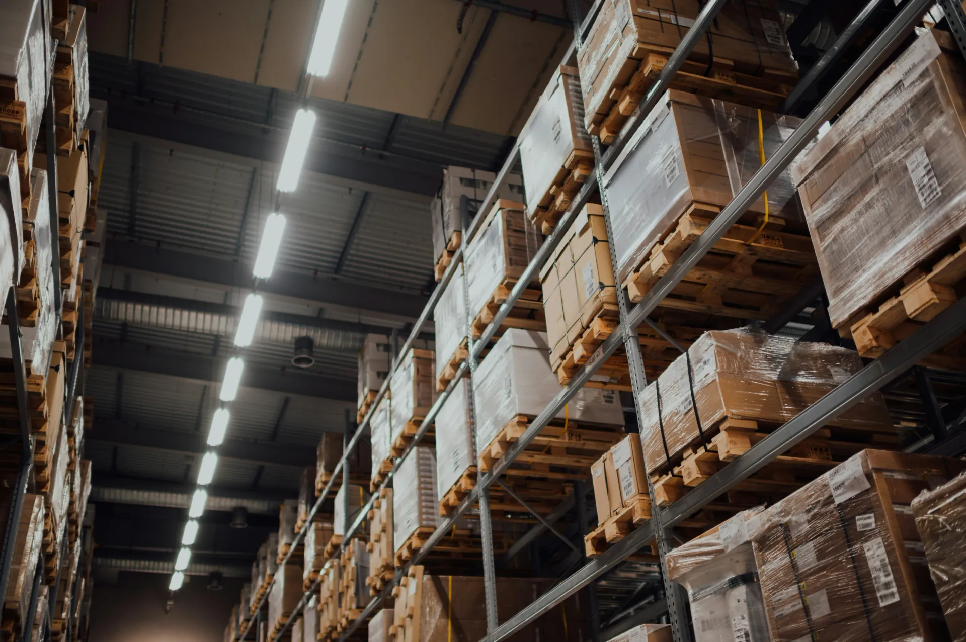 Interior of a large warehouse with tall storage racking under steel roof structure