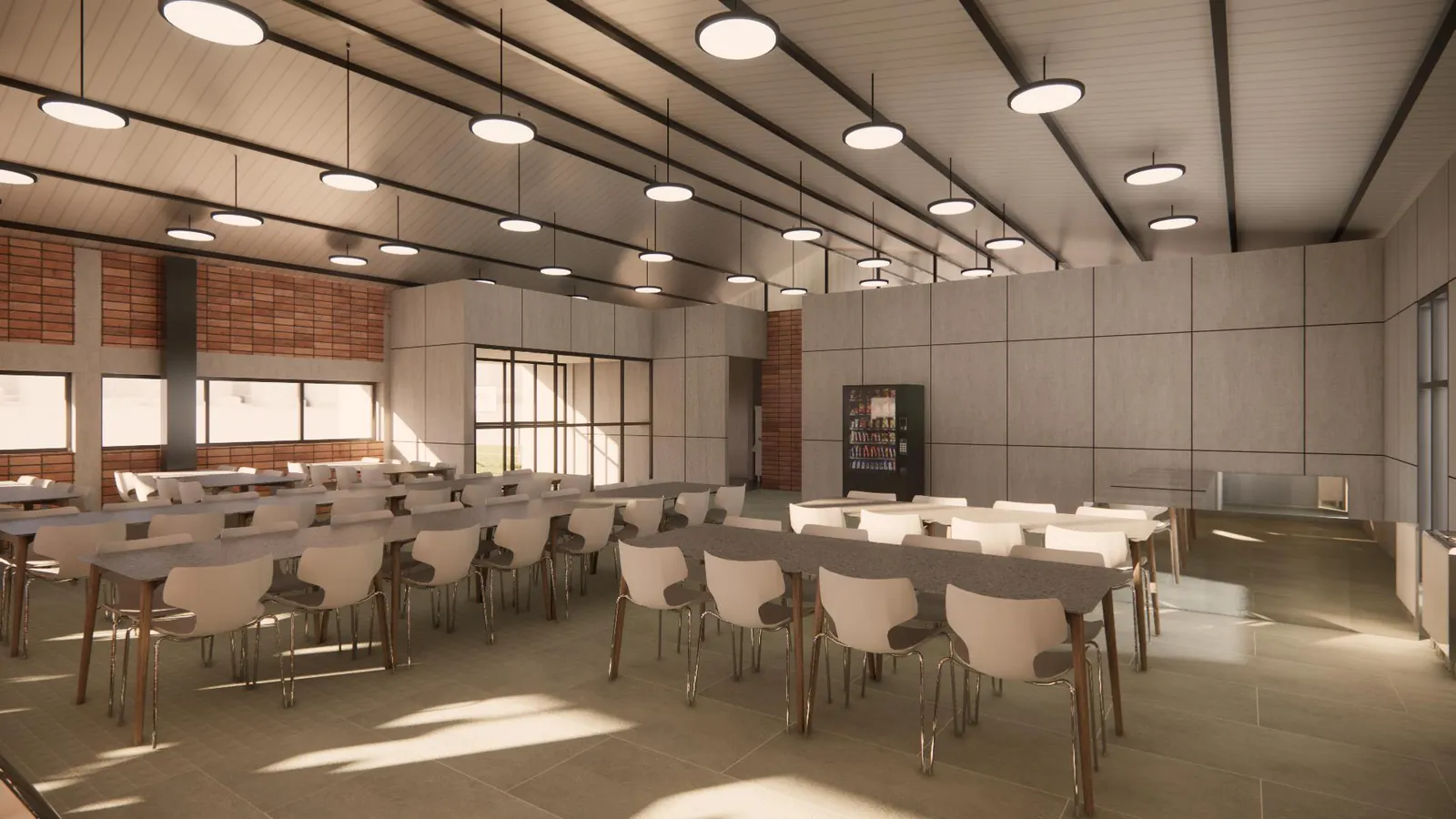 Staff dining hall with rows of loose tables and chairs beside a vending machine
