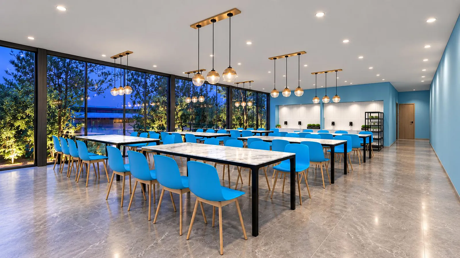 Staff canteen with long tables, bench seating and pendant lights over a glazed wall