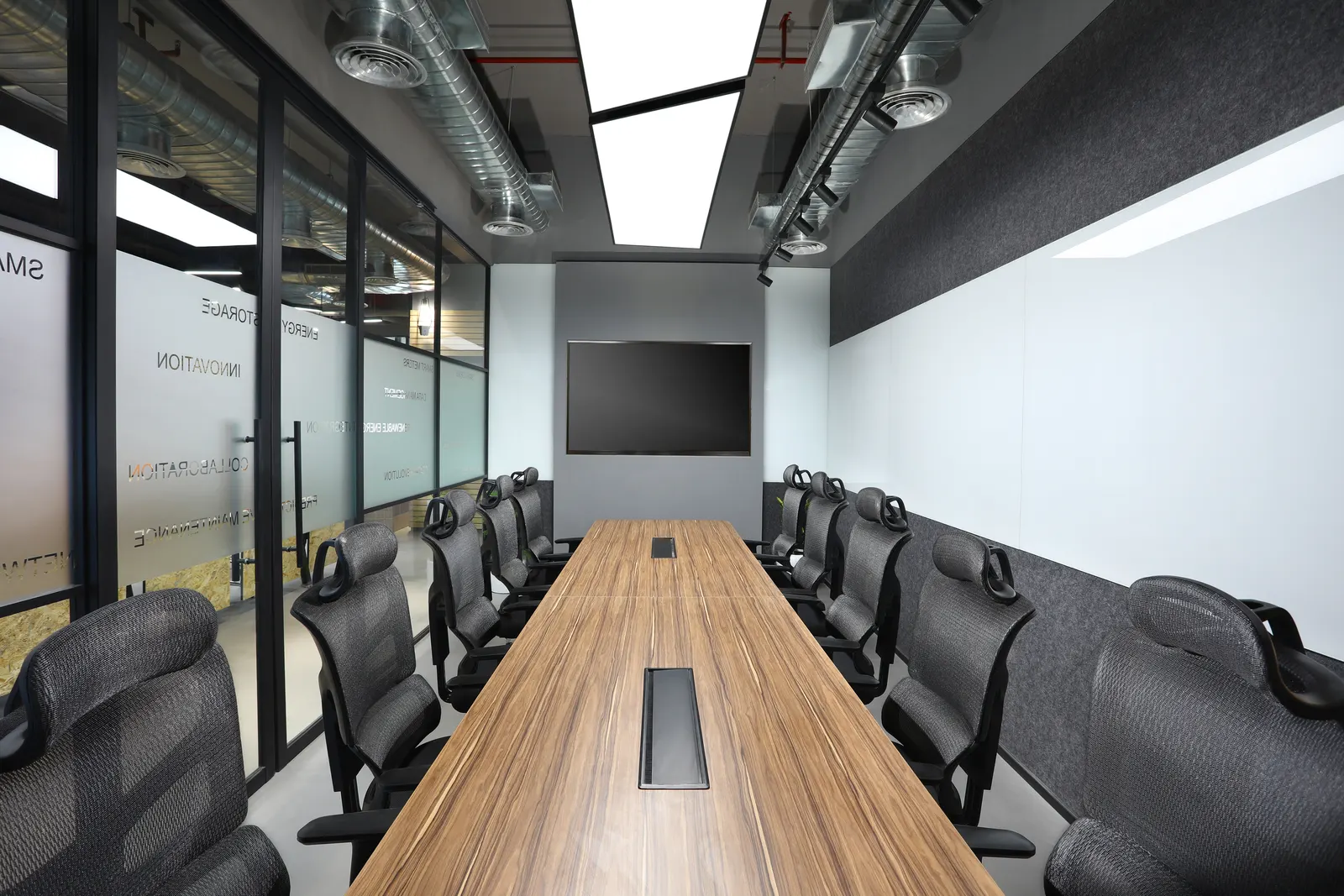 EDF International conference room with a long timber table, black mesh chairs and a wall-mounted screen