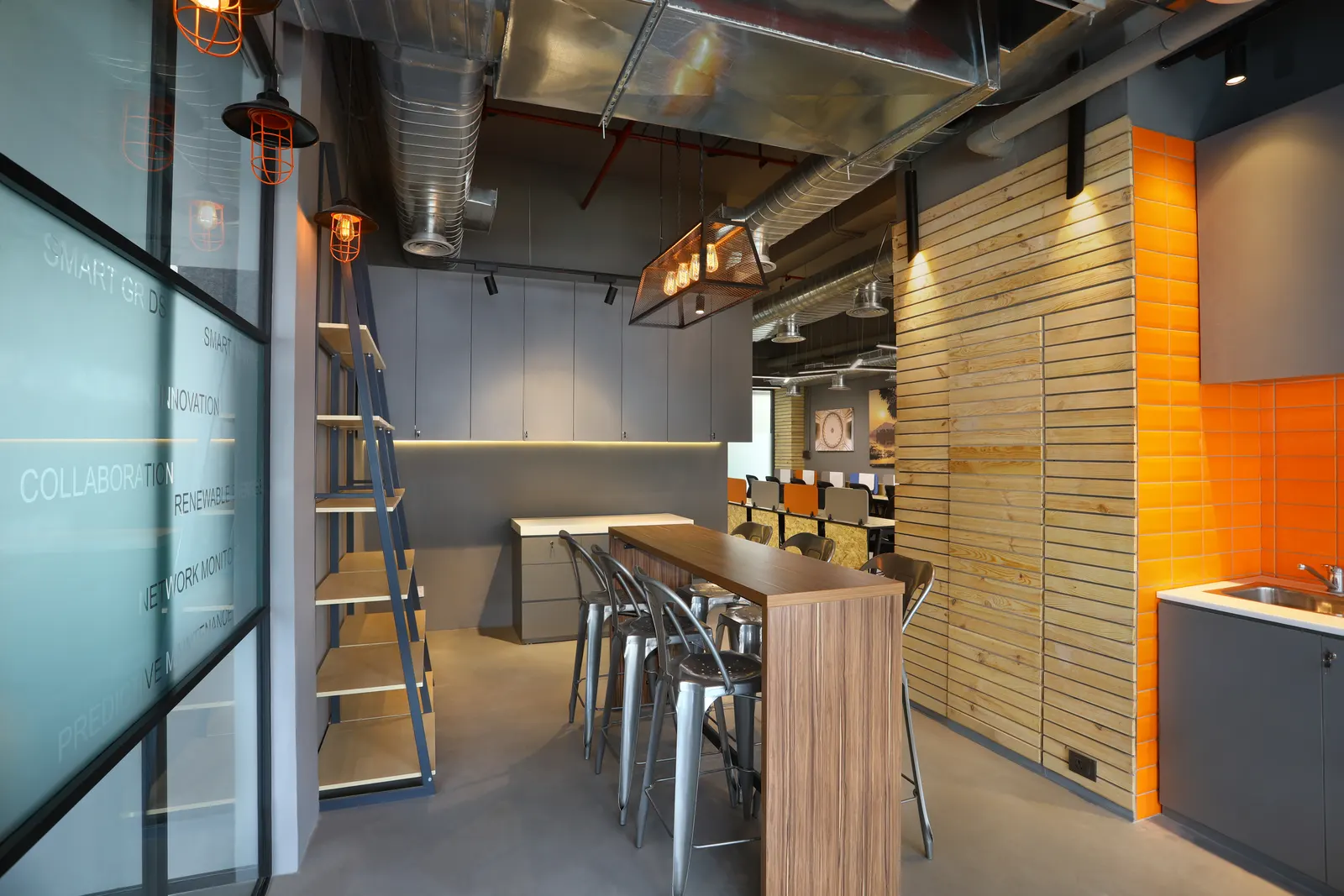 EDF International pantry with a high timber bar table, metal stools and an orange accent wall
