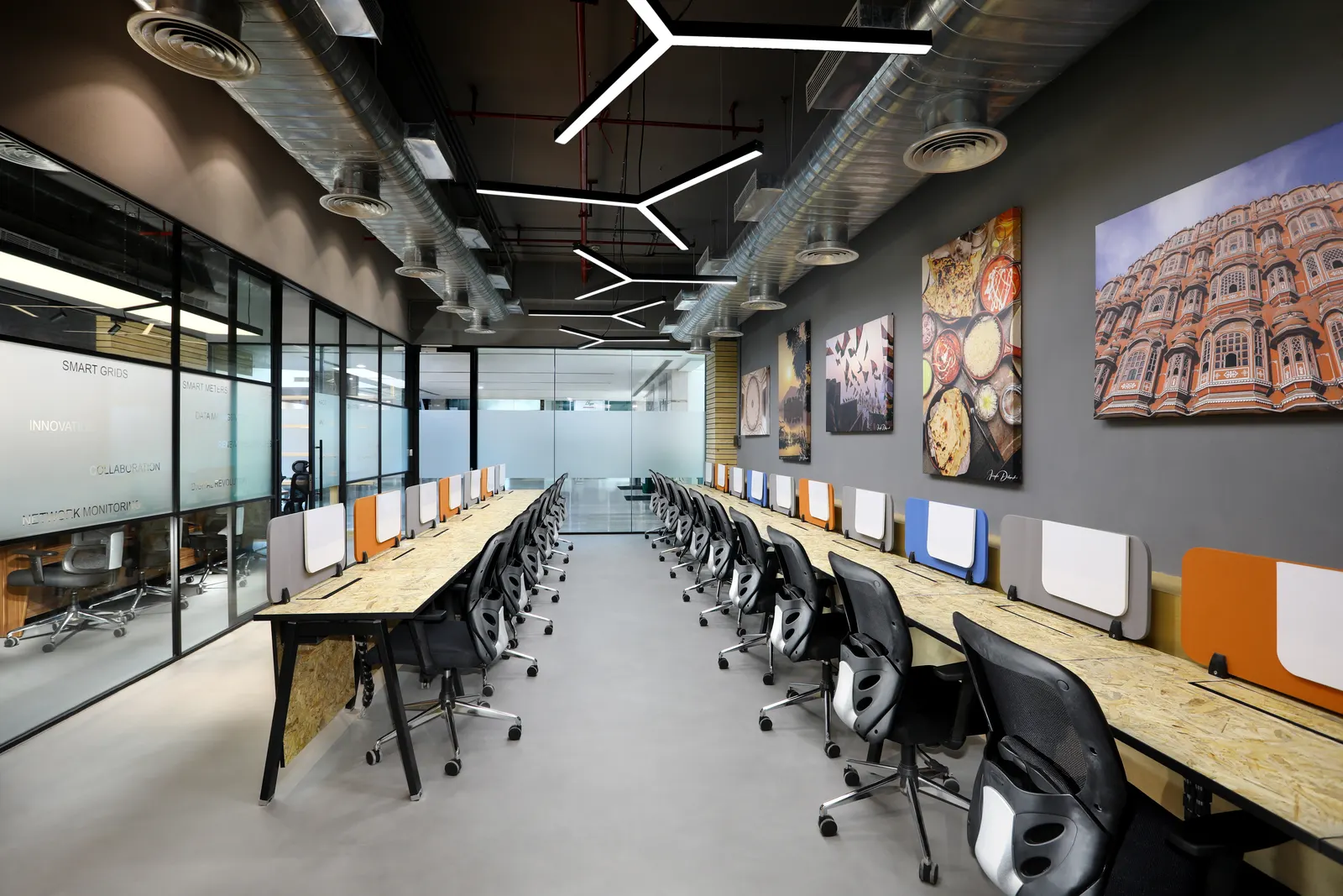 EDF International office workstations with framed artwork, linear pendant lights and exposed ducting in Saket, New Delhi