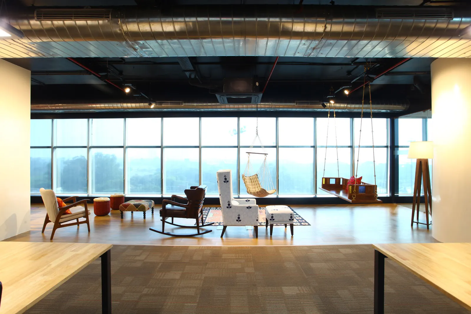 Inshorts Media breakout area with swing chairs and lounge seating by full-height glazing
