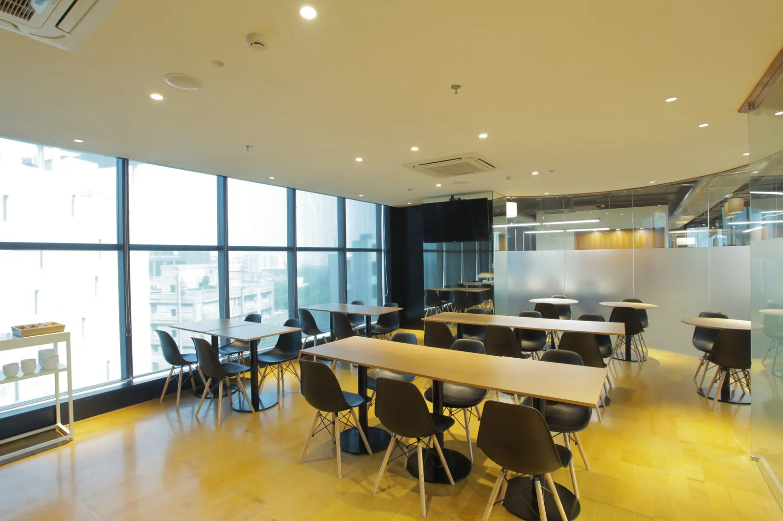Inshorts Media cafeteria with long tables and black chairs beside the windows