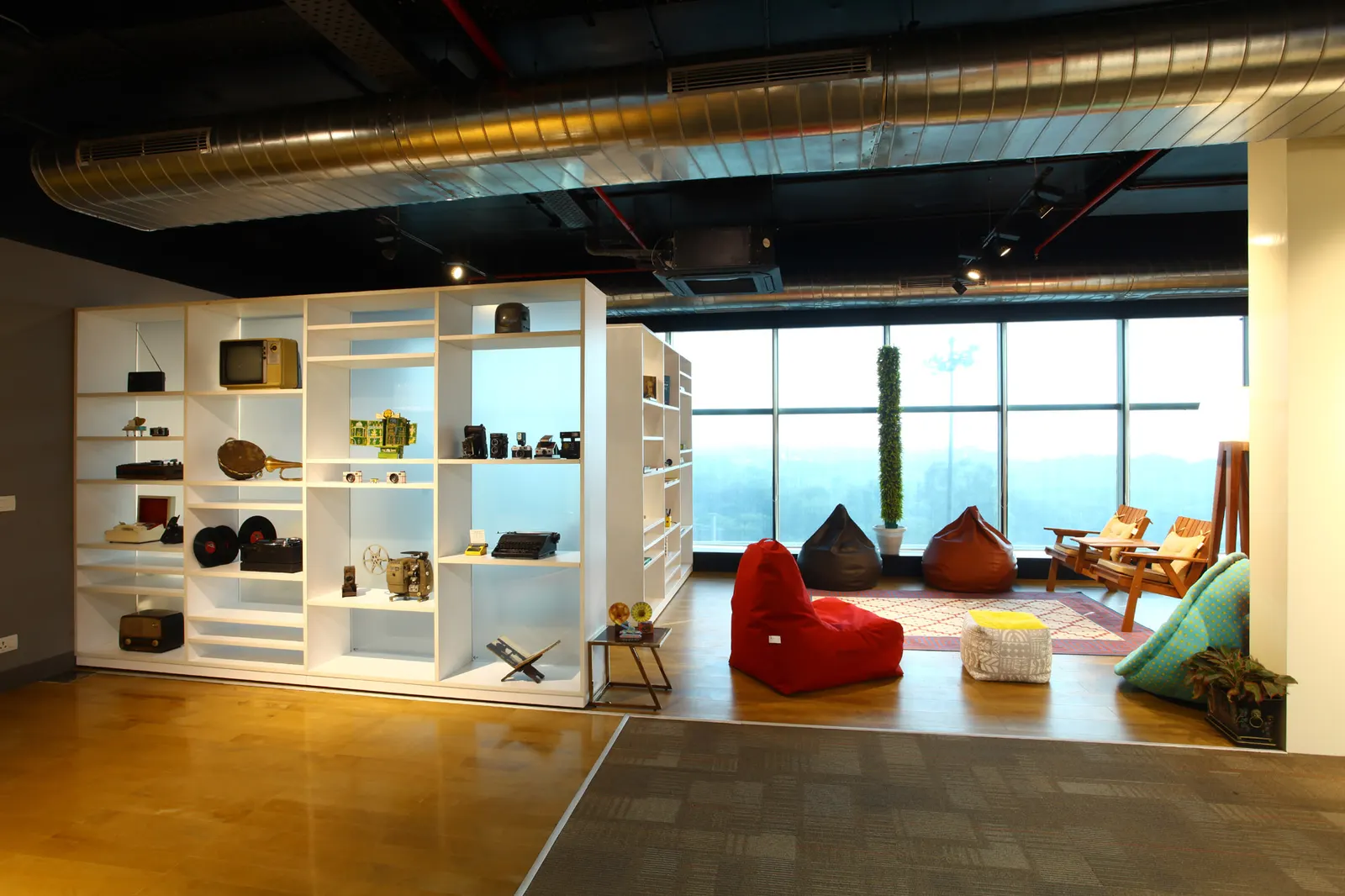 Inshorts Media lounge with white open shelving, bean bags and a view over the city