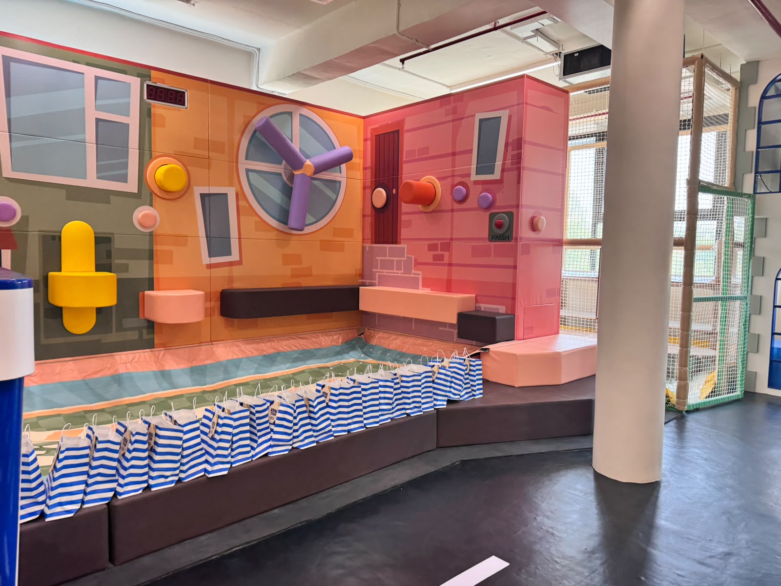 Interactive sensory wall with a spinning pinwheel feature and foam play elements at Kokko Town