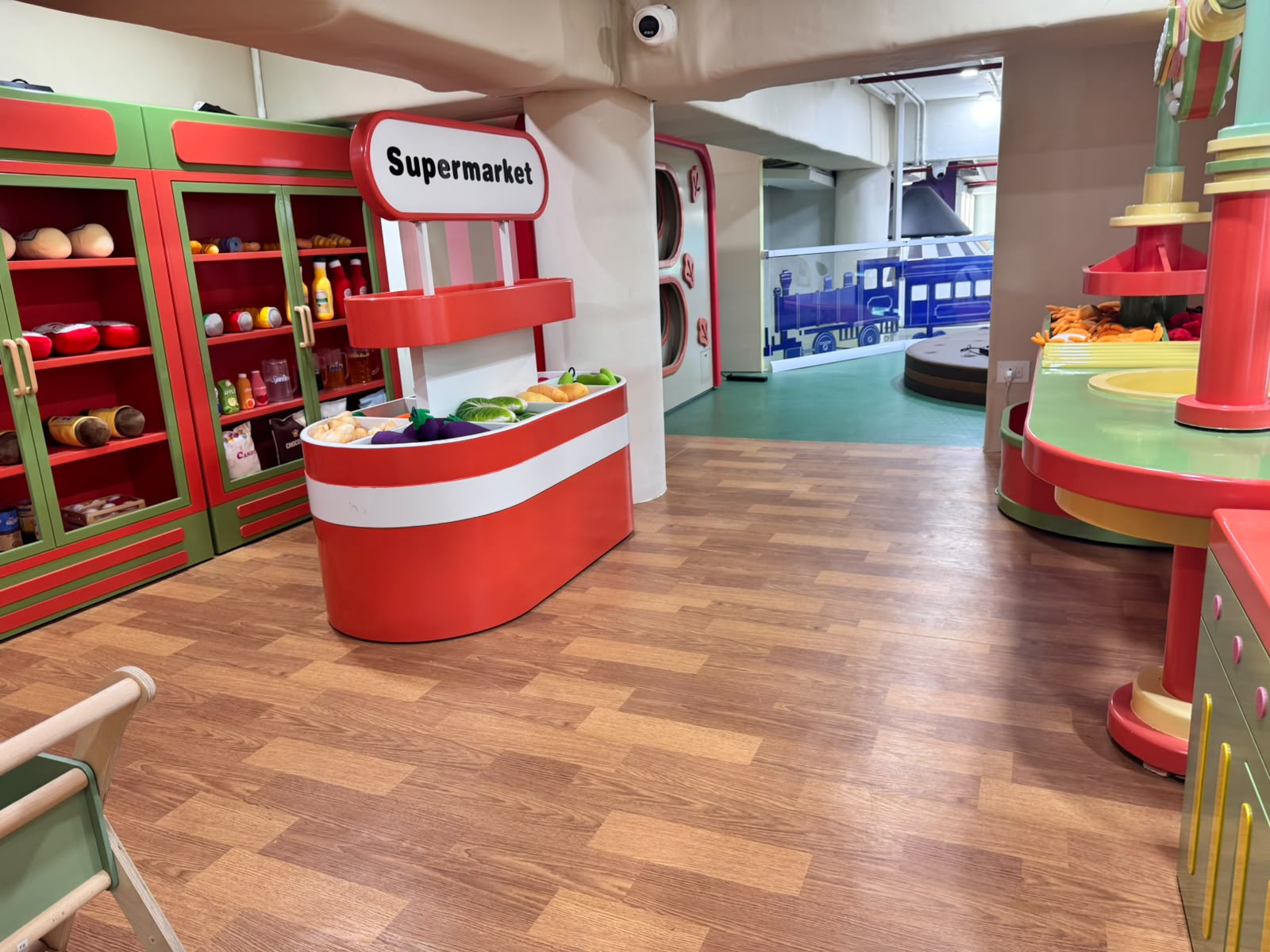 Pretend-play supermarket interior with stocked shelving and checkout counter at Kokko Town
