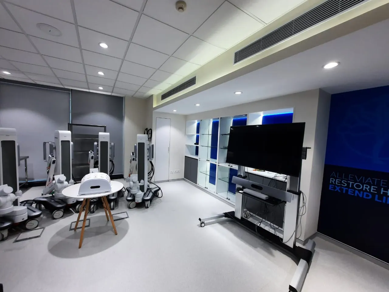 Medtronic room with backlit blue display shelving and mobile screens