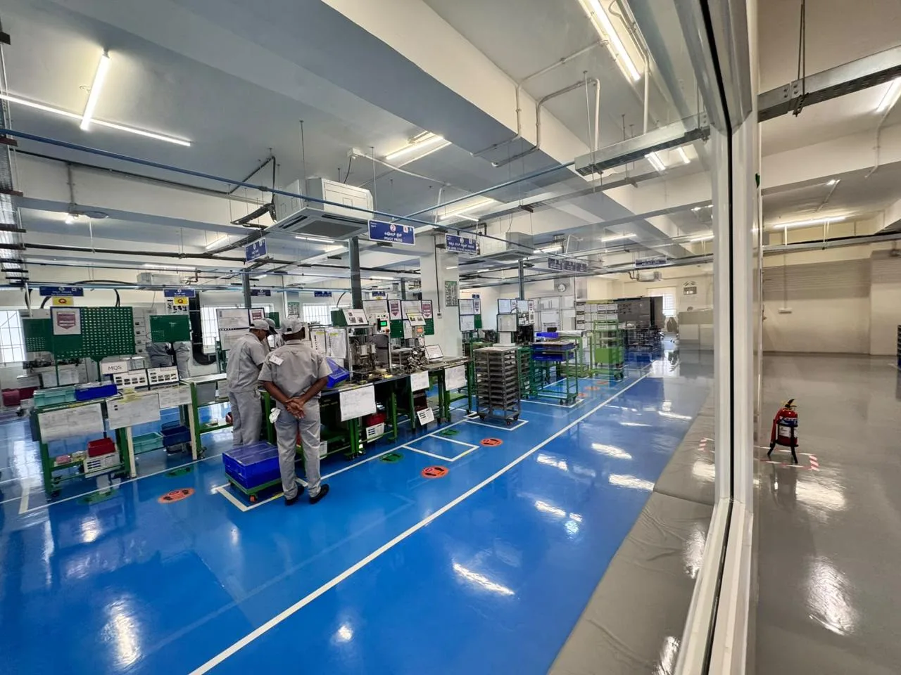 Assembly workstation on the MinebeaMitsumi production floor with process control panels