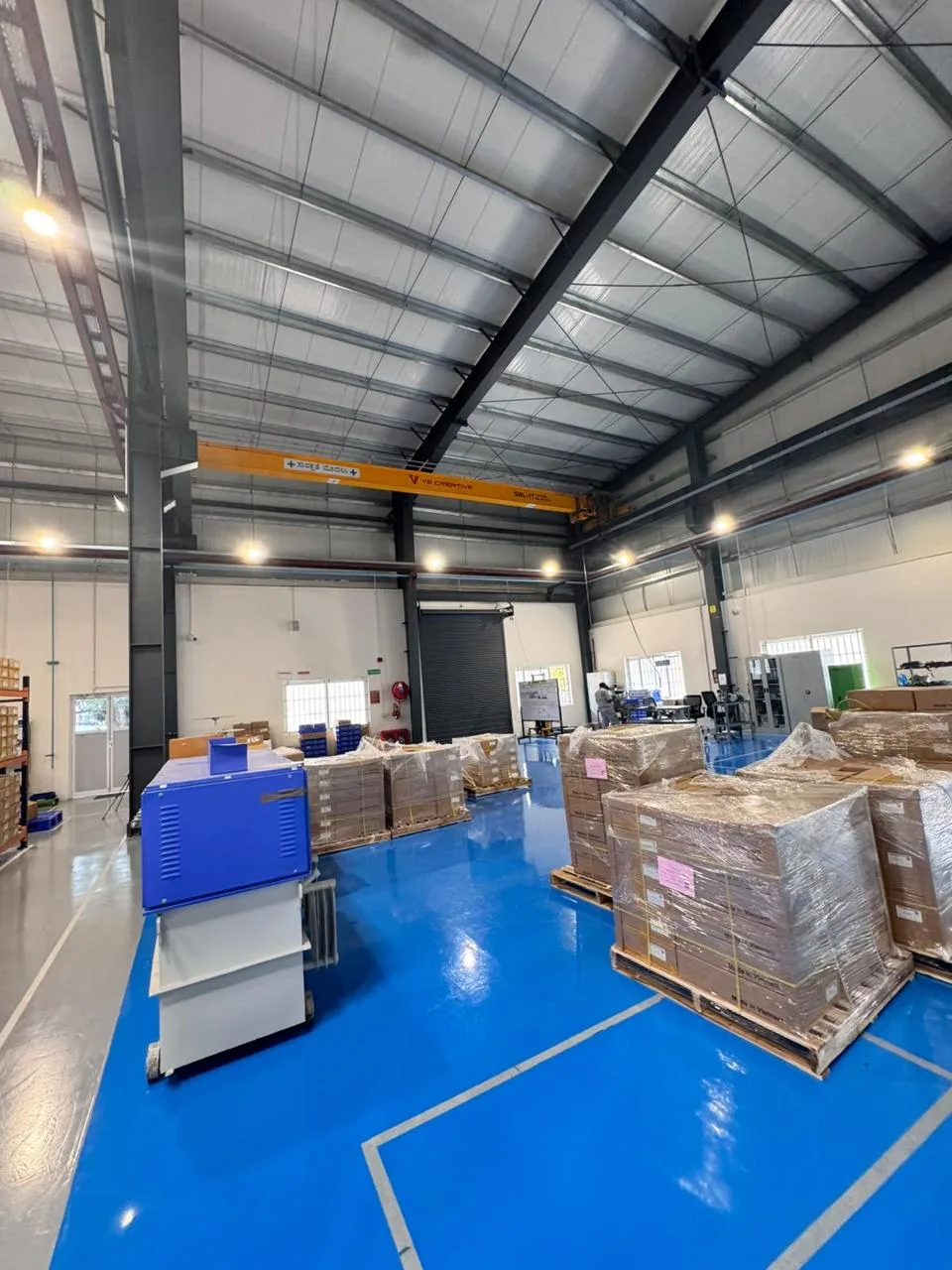 Overhead crane rail above wrapped pallets in the MinebeaMitsumi warehouse