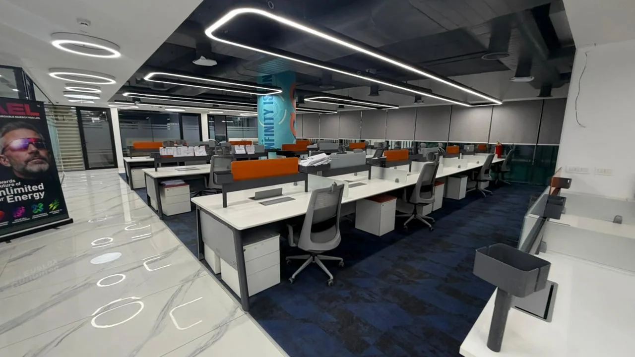 SAEL office breakout area with a branded teal accent pillar among open workstations