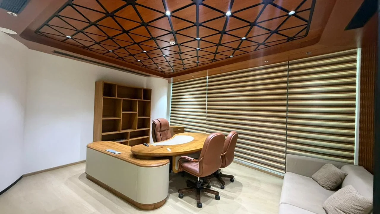 Backlit SAEL signage on a ribbed wood-panel wall above the reception desk at the SAEL Aerocity office