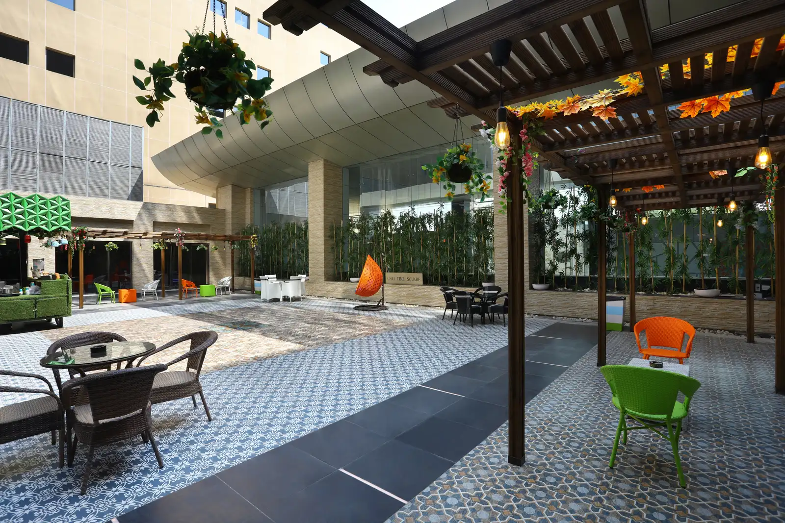 SP Infocity courtyard café tables beneath a pergola with hanging plants