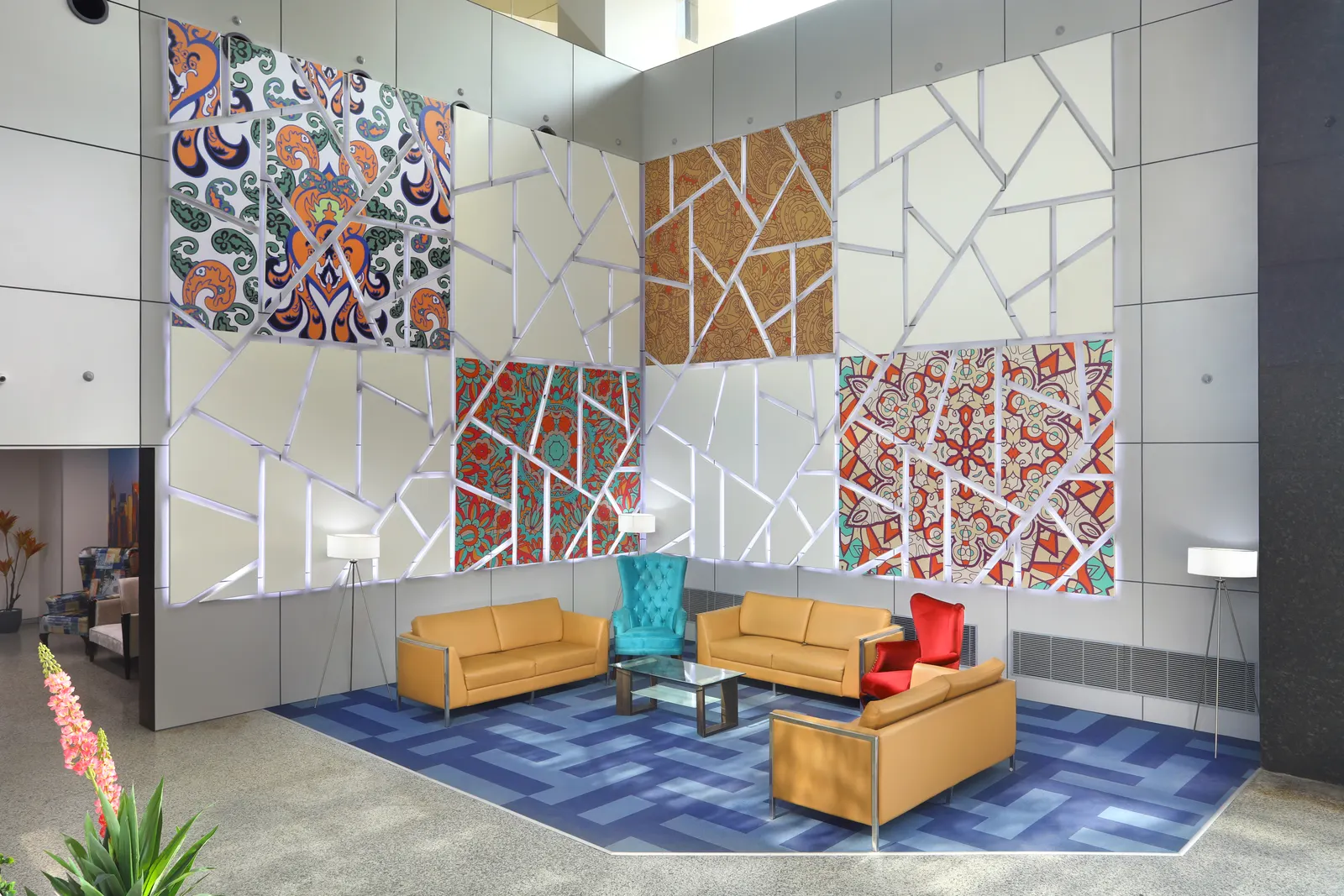 SP Infocity lobby lounge in Gurugram with patterned art panels, leather sofas and a blue carpet