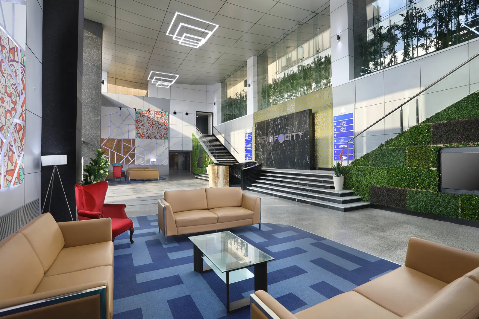 SP Infocity double-height lobby with a green wall, sofas and a feature staircase