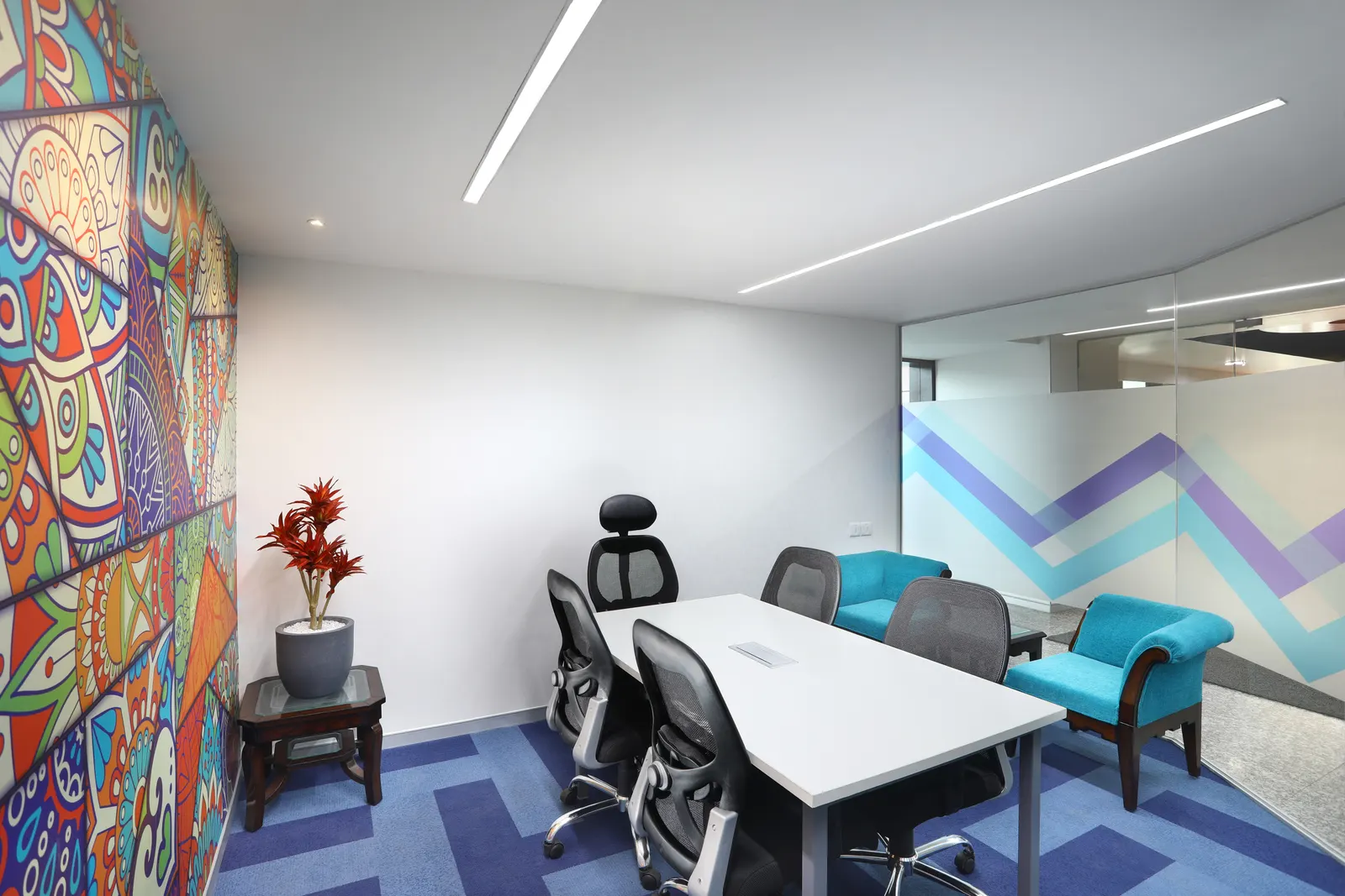 SP Infocity meeting area with a patterned mural wall and a white table