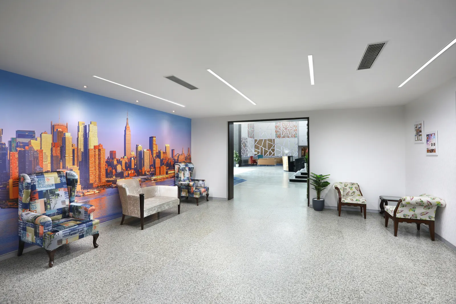 SP Infocity waiting area with a city skyline mural and patterned armchairs