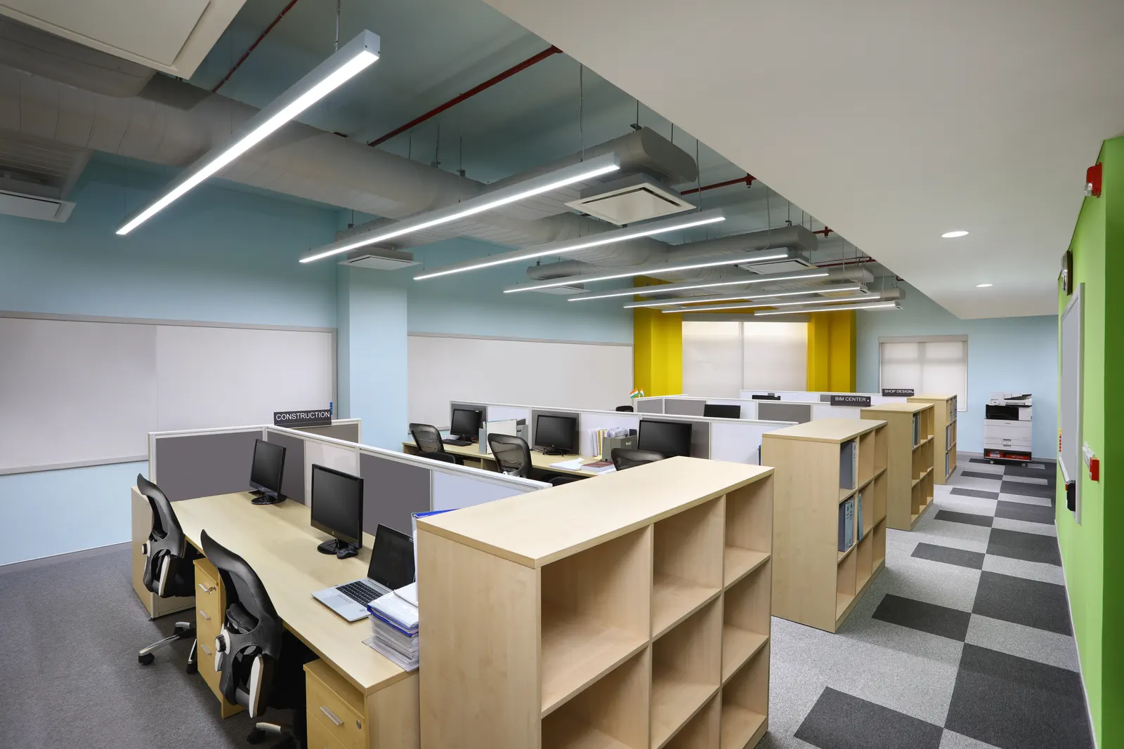 Takenaka head office in Gurugram with timber workstations, storage units and a green accent wall