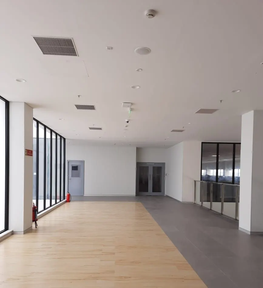 Yanmar factory corridor with wood-finish flooring and glazed partitions
