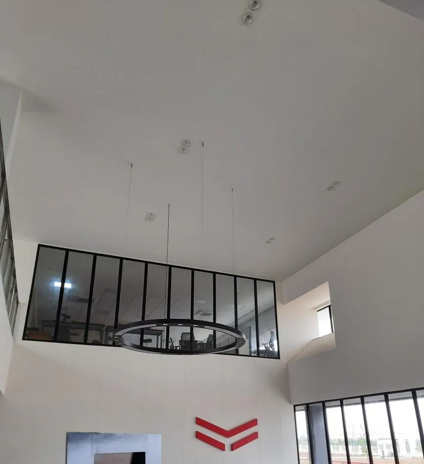 Double-height space at the Yanmar factory with a black-framed glazed opening
