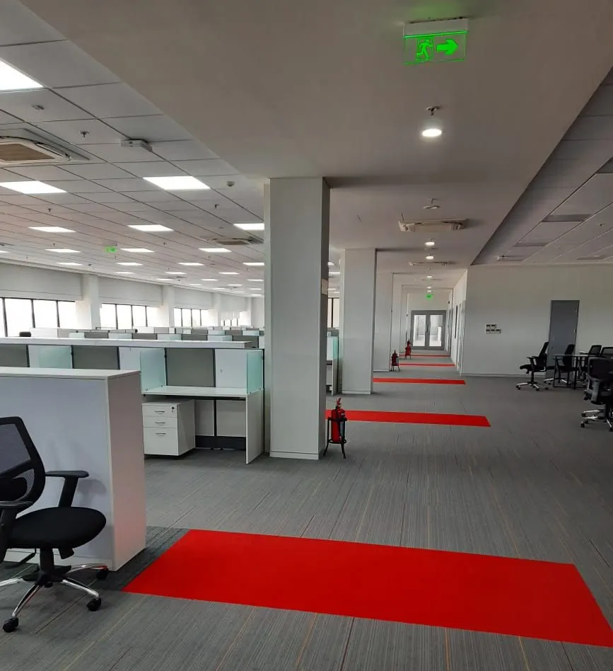 Yanmar factory open office with a red carpet runner and workstation clusters